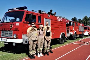 Na boisku szkolnym na tle trzech samochodów strażackich trzech druhów OSP oraz trzech członków Młodzieżowej Drużyny...